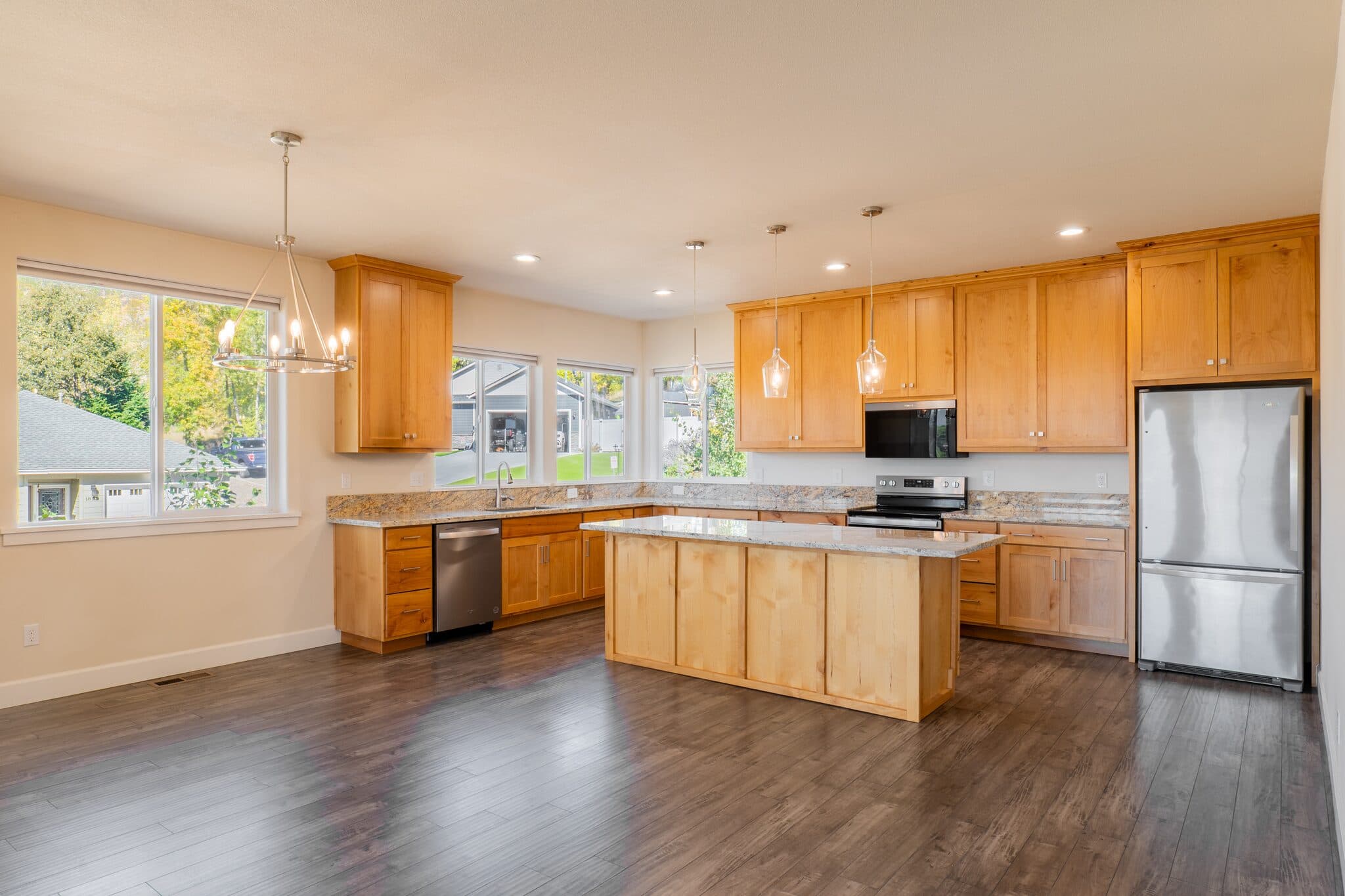 Spacious kitchen with island and wood cabinets — real estate photography by Hahn Media, Oregon